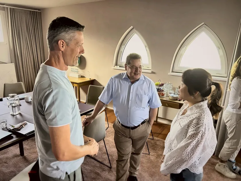 Drei Partner im Gespräch am Fenster
